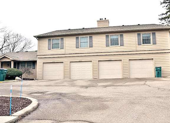 A two-story house with a garage and a driveway.