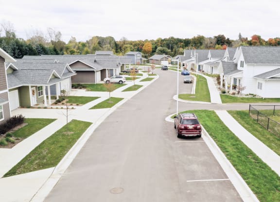 a car driving down a street in a suburban neighbourhood