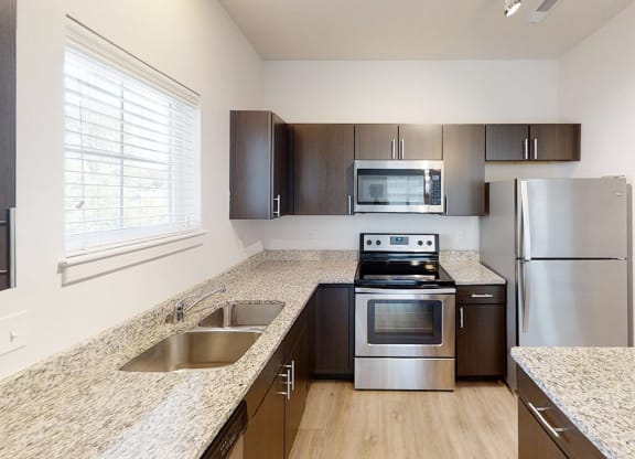 a kitchen with granite counter tops and stainless steel appliances