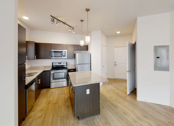 a kitchen with an island and stainless steel appliances