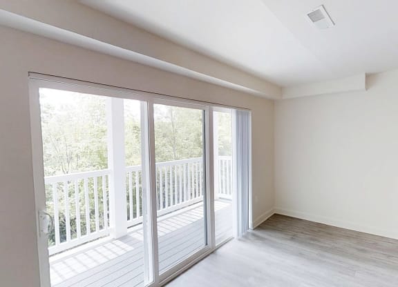 an empty living room with sliding glass doors to a balcony