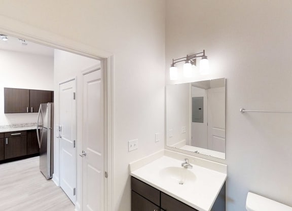 a white bathroom with a large mirror and a sink