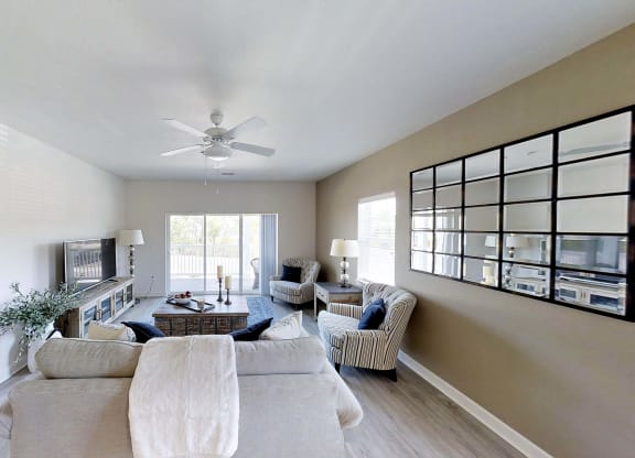 a living room with a couch and a ceiling fan