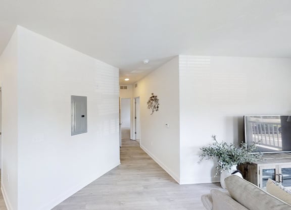 the living room and hallway of a home with white walls