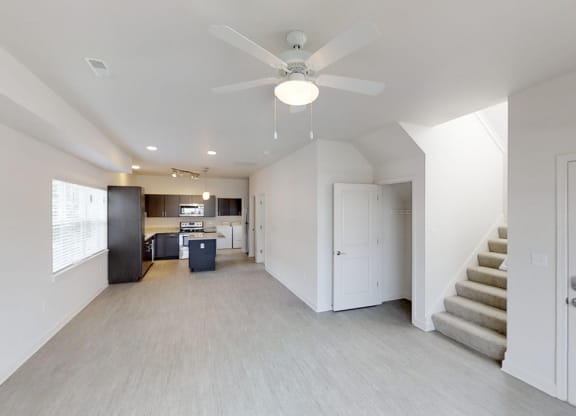 a living room and kitchen with a ceiling fan