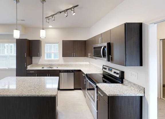 a large kitchen with granite counter tops and stainless steel appliances
