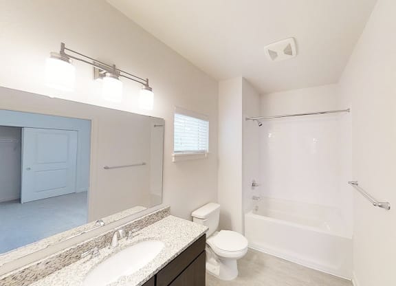 a bathroom with a shower toilet and sink and a mirror