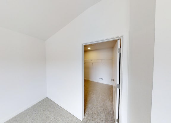a bedroom with a door open to a closet