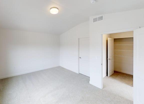 a living room with white walls and a closet