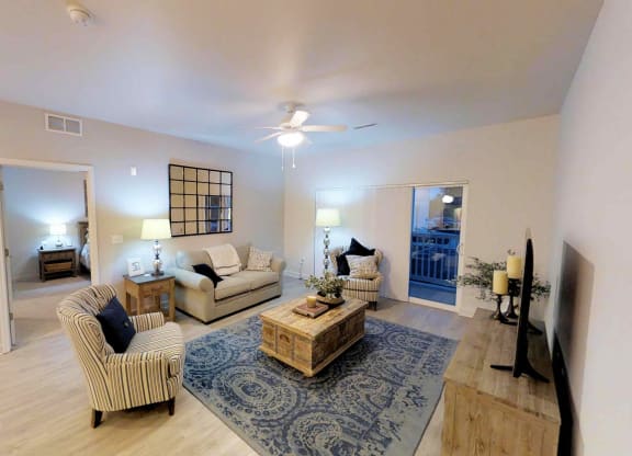 a living room with couches and chairs and a rug