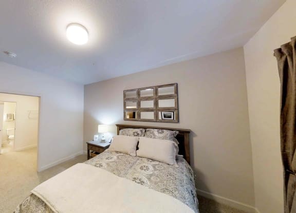 a bedroom with a bed and a door to a bathroom