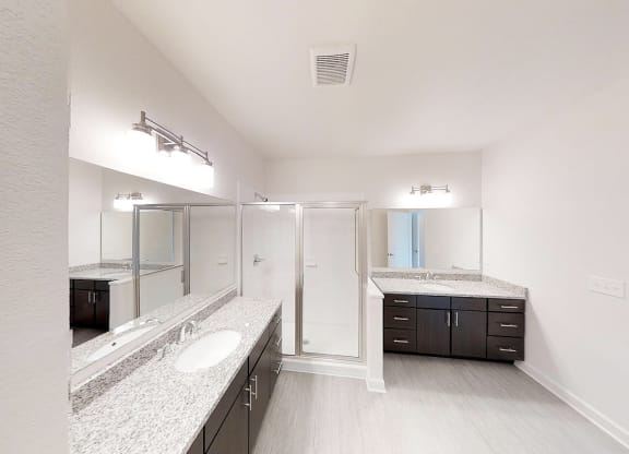 a bathroom with a shower and sinks and a mirror