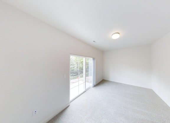 a living room with white walls and a sliding glass door