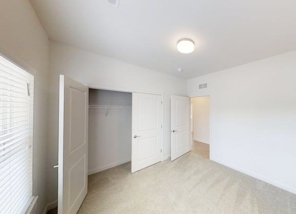 an empty room with white walls and white closet doors