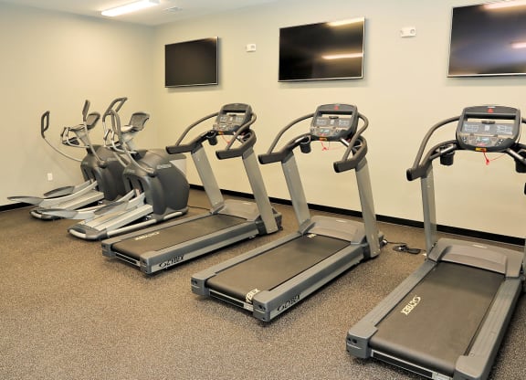 a row of exercise equipment in a gym