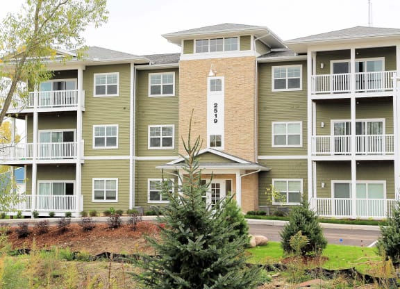 an apartment building with trees in front of it