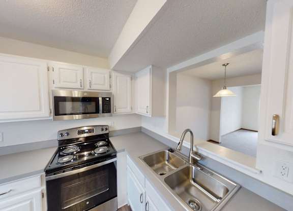 A kitchen with white cabinets and stainless steel appliances.