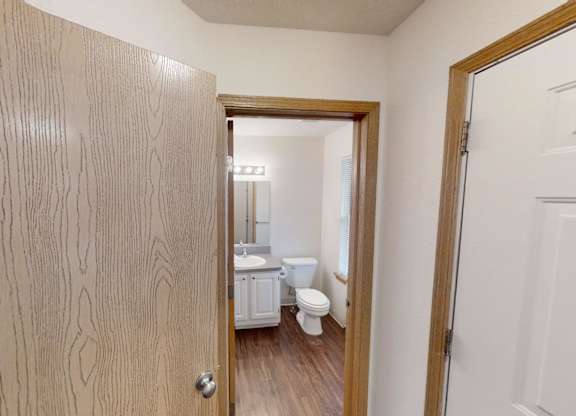 A bathroom with a toilet, sink, and mirror.