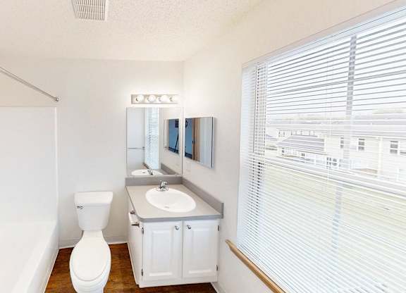 A white toilet sits in a small bathroom next to a sink.
