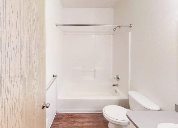 A white bathroom with a toilet, sink, and bathtub.