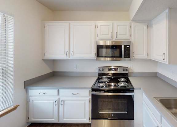 A kitchen with white cabinets and stainless steel appliances.