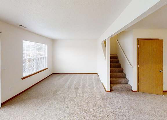 A room with a staircase leading to another room.