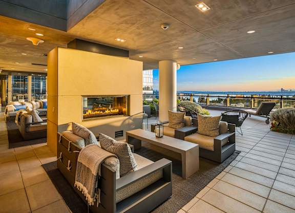 a outdoor terrace with couches and chairs and a fireplace at Two Lincoln Tower, Bellevue
