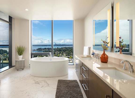 A modern bathroom with a large window overlooking a cityscape.