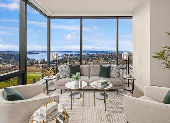a living room with couches and chairs and a view of the city and water at Two Lincoln Tower, WA, 98004