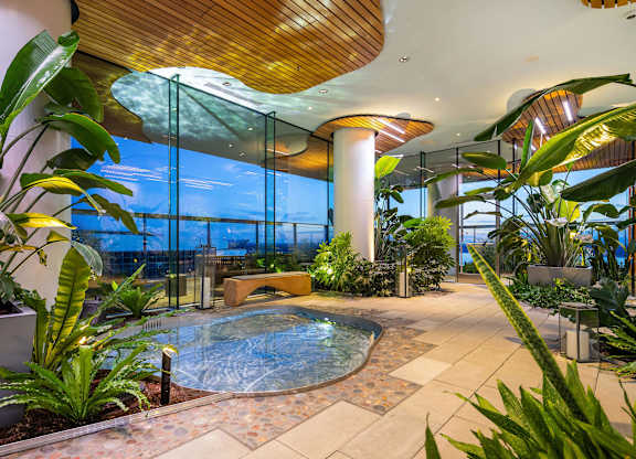 a hotel lobby with a jacuzzi swimming pool and plants at Two Lincoln Tower, Bellevue, WA, 98004
