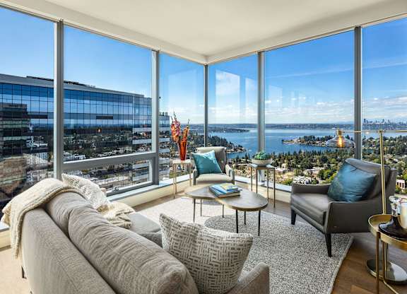 a living room with a couch and chairs and a view of the city and water at Two Lincoln Tower, Bellevue, WA