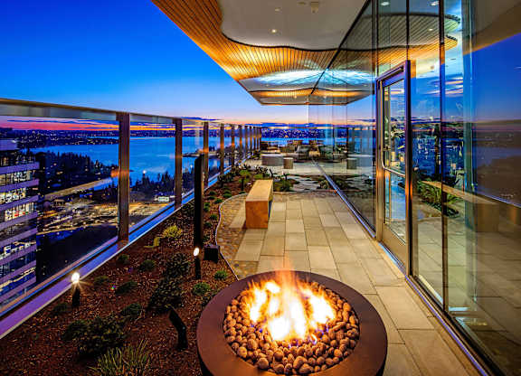 a fire pit on a balcony overlooking a city at night at Two Lincoln Tower, Bellevue, WA