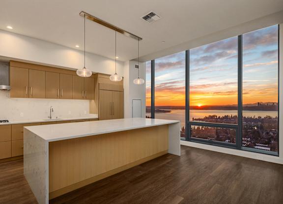 A modern kitchen with wooden cabinets and a large island at Two Lincoln Tower, Bellevue, WA.