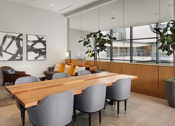 A conference room with a long table and grey chairs.