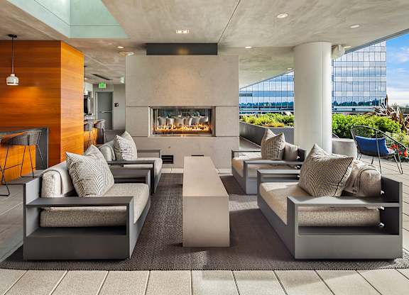 An outdoor patio with seating and a fireplace at Two Lincoln Tower in Bellevue, WA.