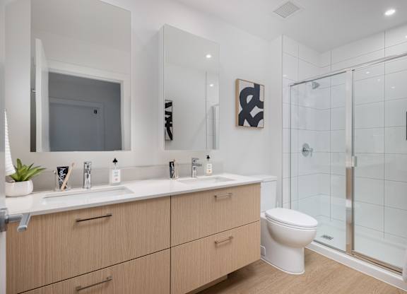 A bathroom with a toilet, sink, and mirror.