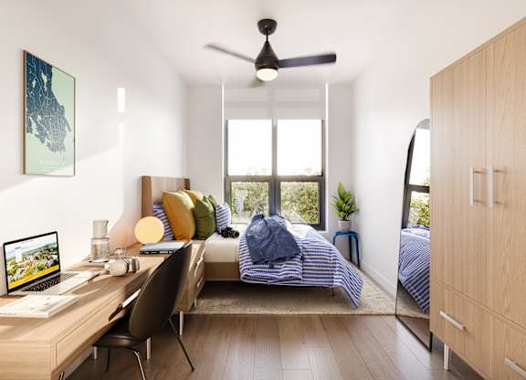 A room with a bed, desk, and chair.