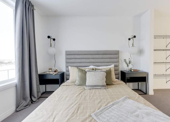 A bedroom with a large bed and a grey headboard.