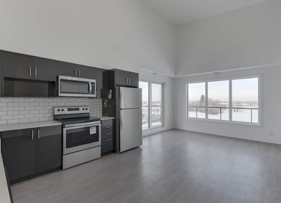 A kitchen with black cabinets and stainless steel appliances.