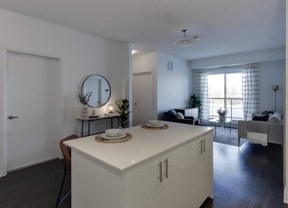 A white kitchen island with a round mirror above it.