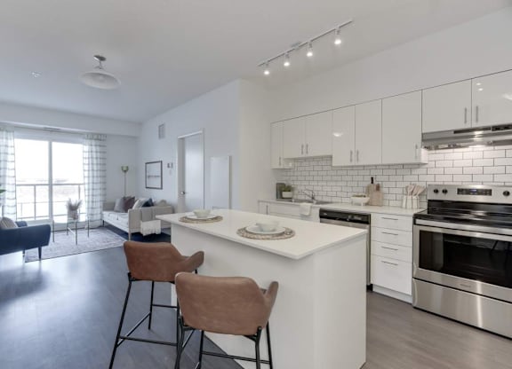 A modern kitchen with white cabinets and stainless steel appliances.