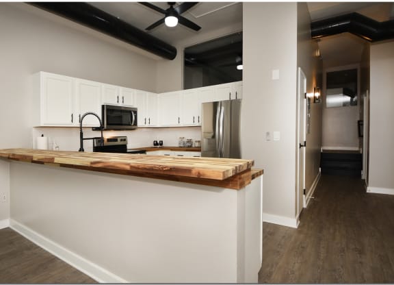 a kitchen with white cabinets and a wooden counter top