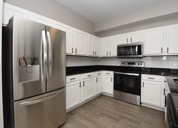 a kitchen with stainless steel appliances and white cabinets