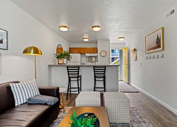 A living room with a brown leather couch and a gold floor lamp. at Vivo Toledo Apartments, Toledo, OH