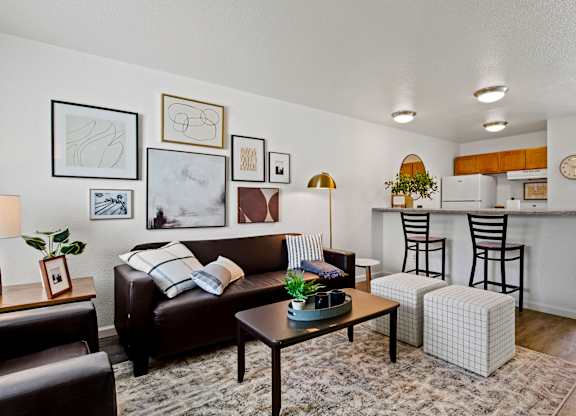 A living room with a brown couch, a coffee table, and a striped pillow. at Vivo Toledo Apartments, Toledo, OH, 43607