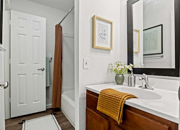 A bathroom with a white sink and a yellow towel. at Vivo Toledo Apartments, Ohio
