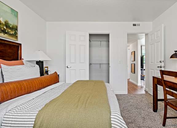 A bedroom with a bed, a chair, and a painting on the wall. at Vivo Toledo Apartments, Toledo