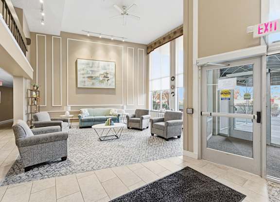 A living room with a grey sofa, armchairs and a coffee table.