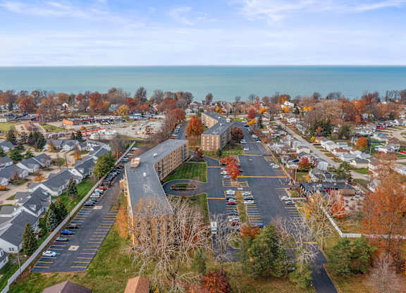 A view of a residential area with houses and trees in autumn colors.