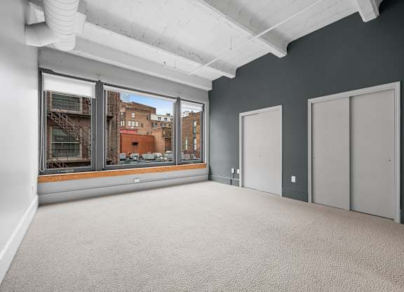 A room with a view of the city through large windows.